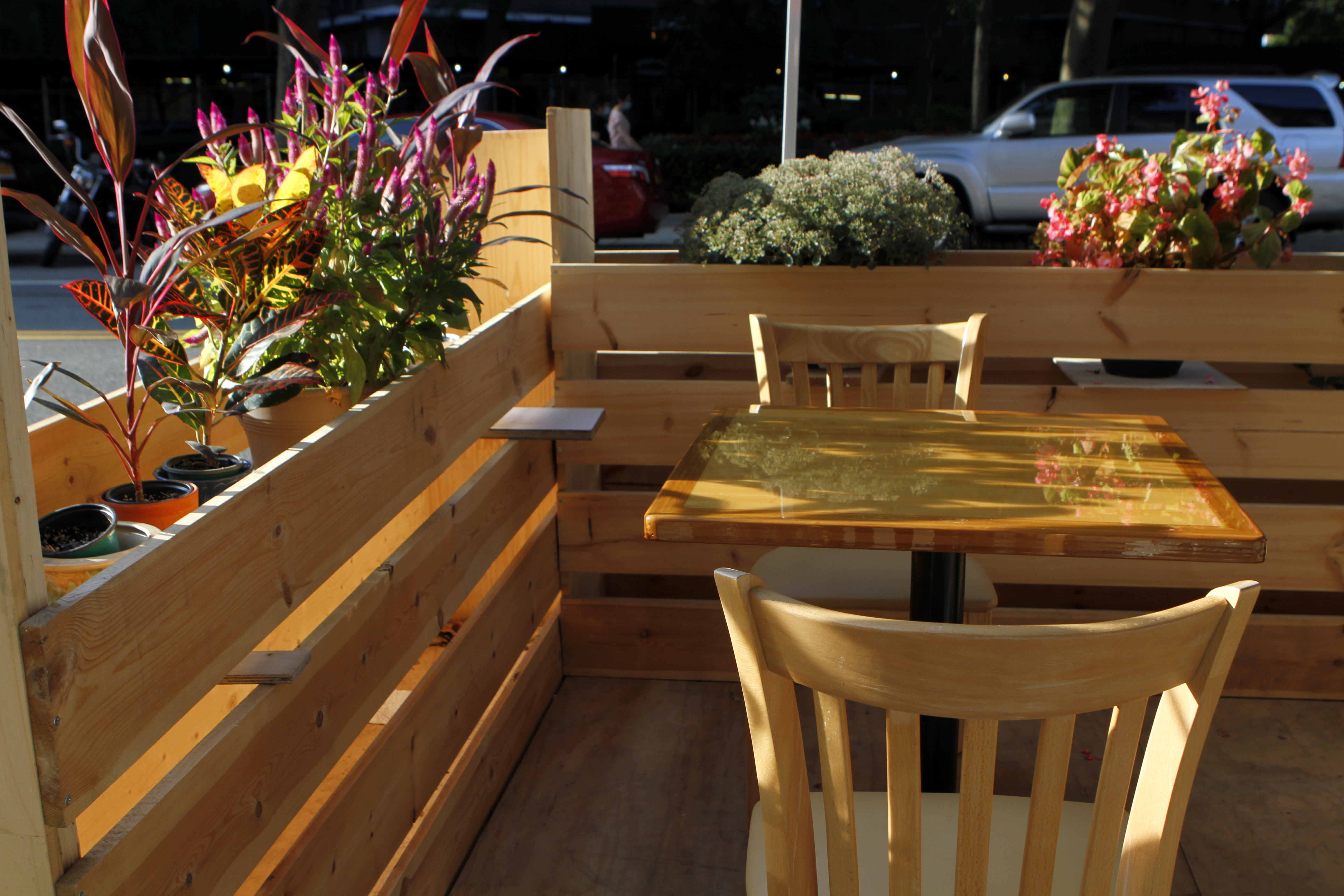Outdoor seating with flower box planters at May Kaidee East Broadway in NYC